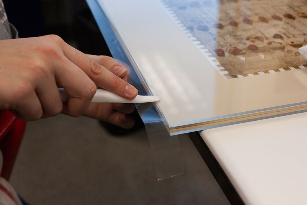 Applying archival sealing tape to top layers of sealed package