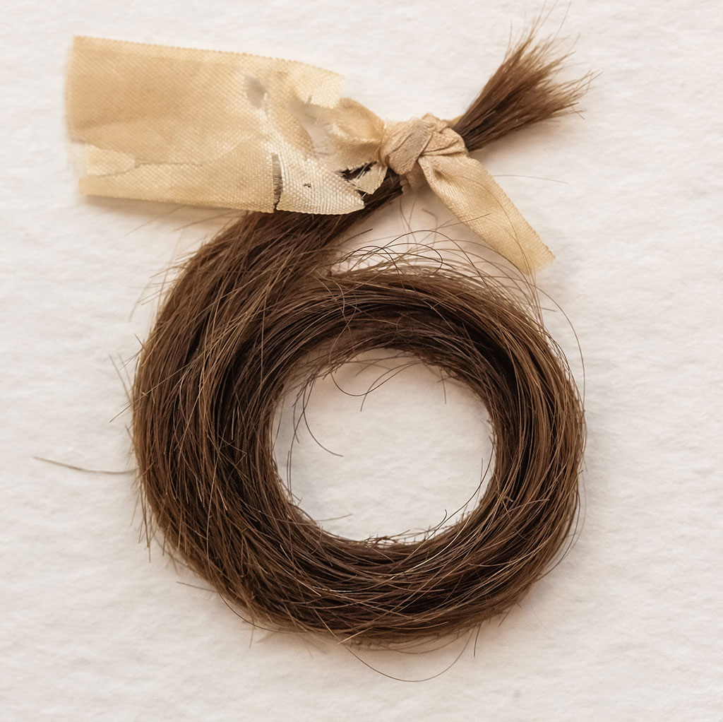 A hair lock after stabilization. The thread and backing textile are almost invisible.