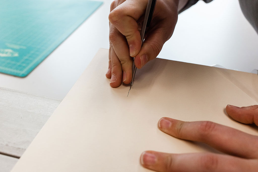 Cutting slits in 4-ply rag board for polyethylene strapping