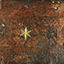 An early binding of an incunable—with blind stamping, a star boss, and remnants of leather straps and brass clasps—shows heat and water damage from a fire.