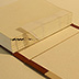 This model reveals the inside of a case bound book. The spine cross-section shows French or link sewing over linen tapes and spine linings. The staggered printed bars on the folds indicate the sequence of signatures. Turn-ins are visible along the edges of the case.